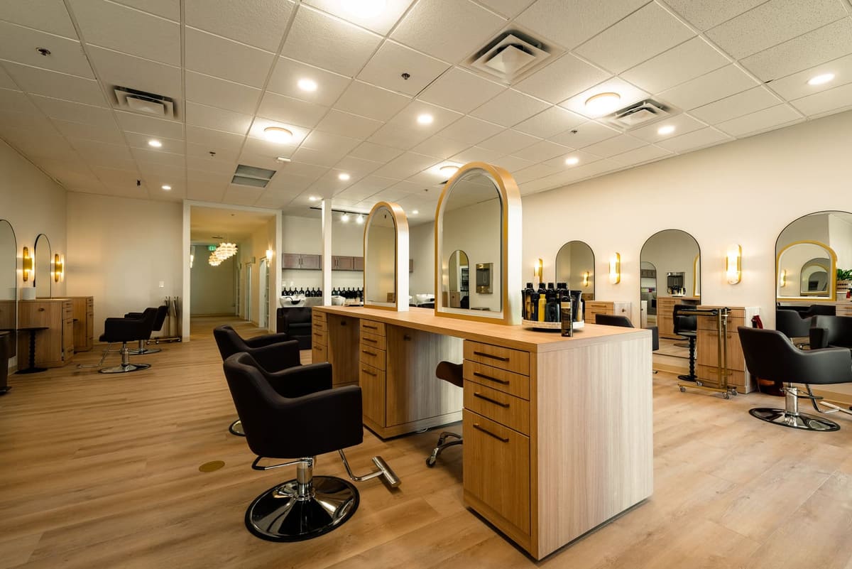 Oak styling island under arched mirrors with more stations lining the salon walls