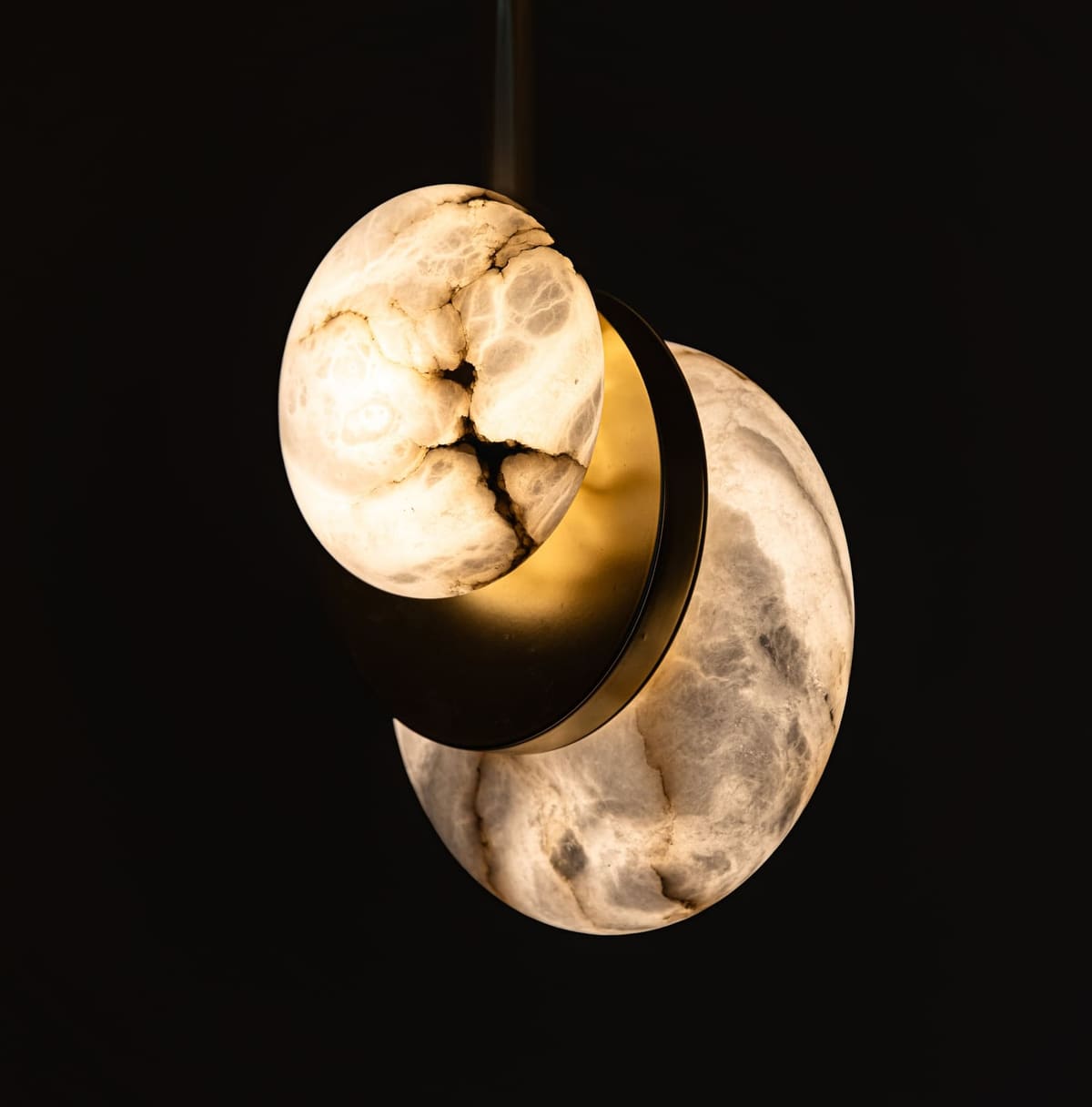 Alabaster globe pendant light glowing against a dark background