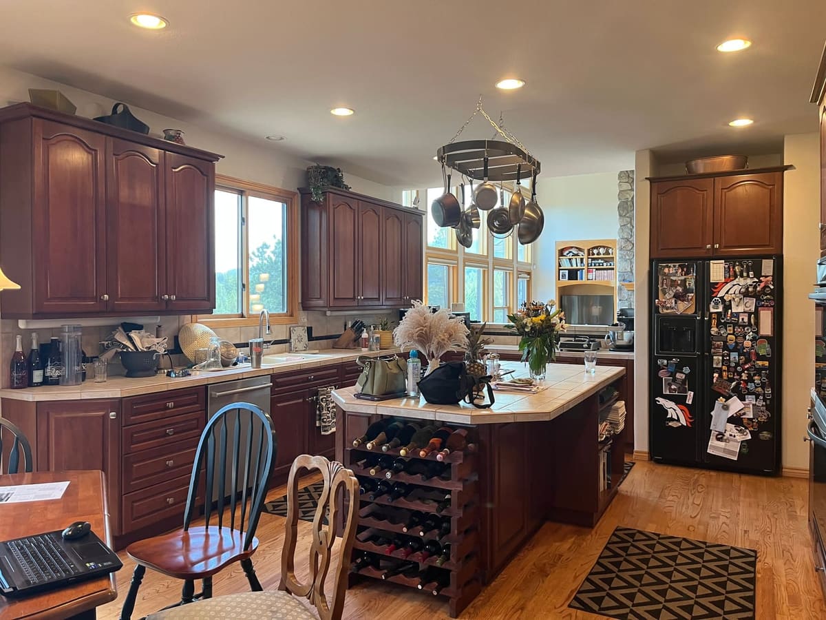 Before the remodel: cherry kitchen island with a built-in wine rack under a hanging pot rack