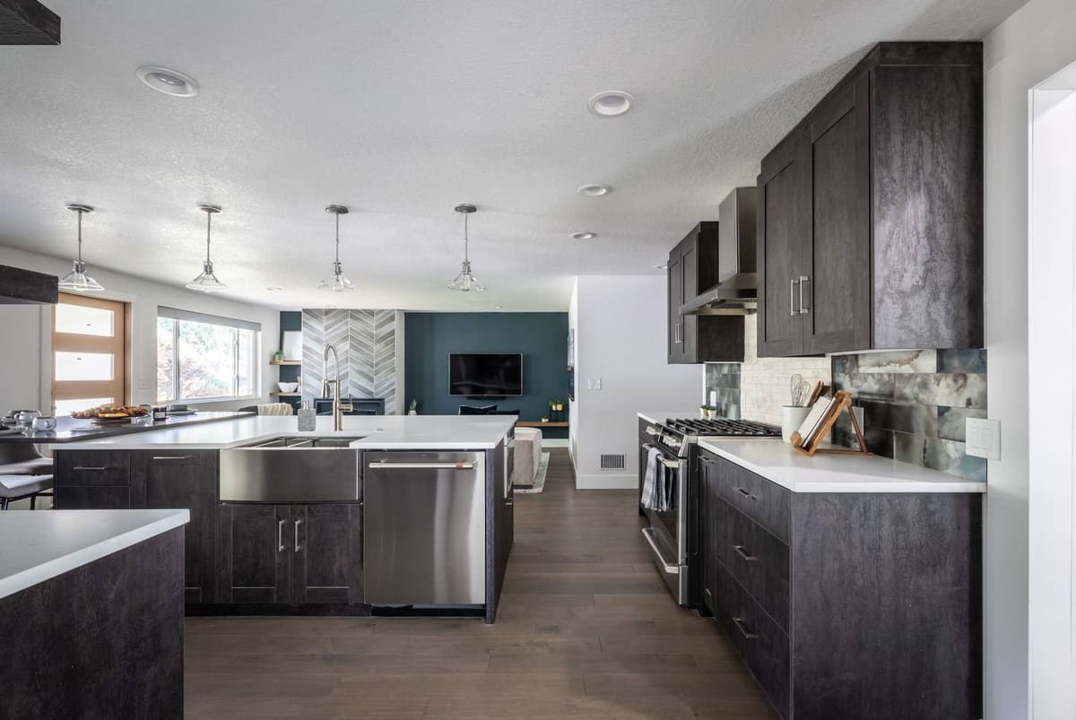 Kitchen with charcoal-stained cabinets, a farmhouse sink in the island and stainless appliances
