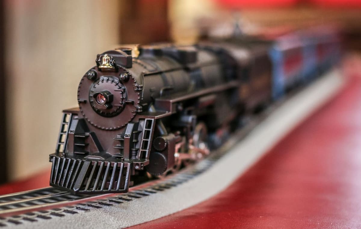 Close view of a black model steam locomotive running on a red-skirted holiday display