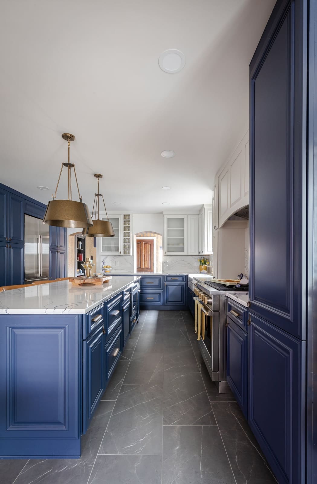 Navy island and full-height navy pantry cabinet along the kitchen