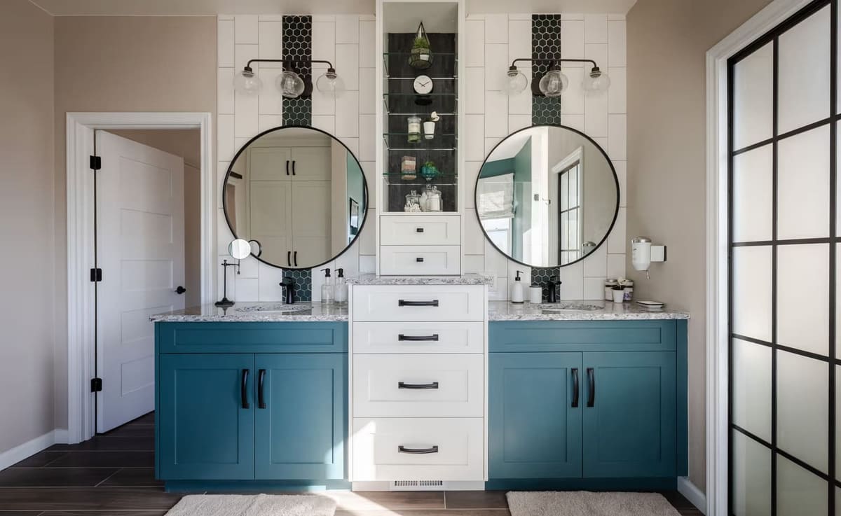 Teal and white double vanity with round black mirrors and a black hexagon tile inlay
