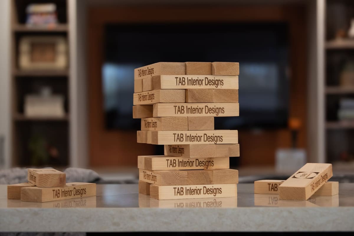 Engraved wood stacking blocks on a pale quartz counter with a basement media wall blurred behind