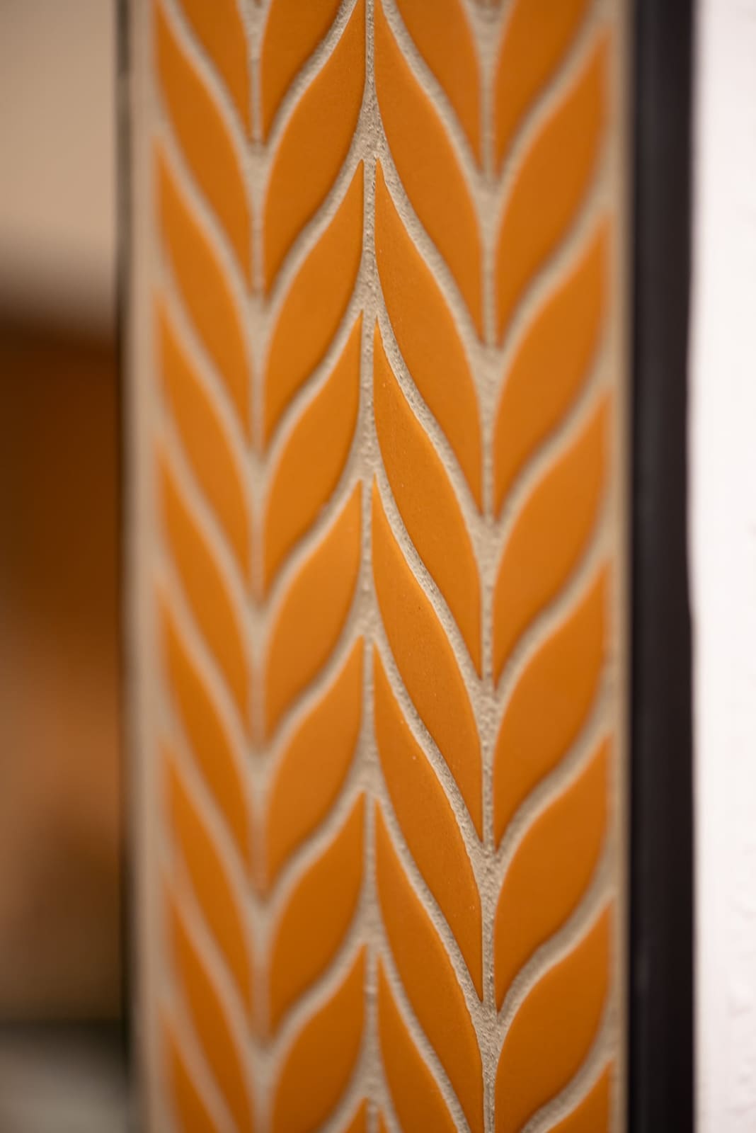 Detail of the orange chevron mosaic running up the shower wall