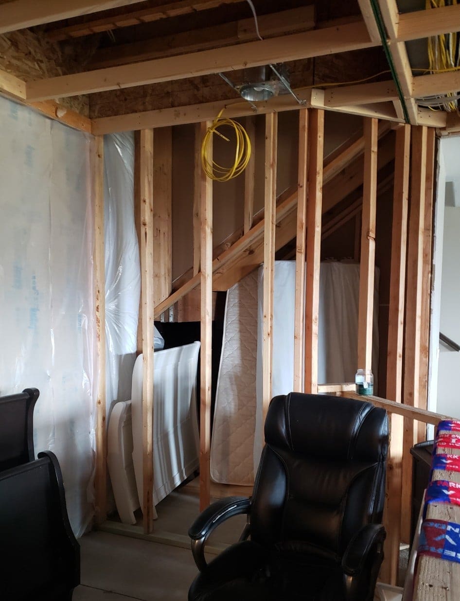 Before the remodel: bare stud walls and exposed wiring in the basement