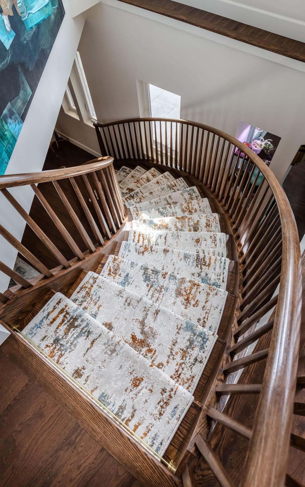Overhead view of the curved stair and its cream-and-rust runner